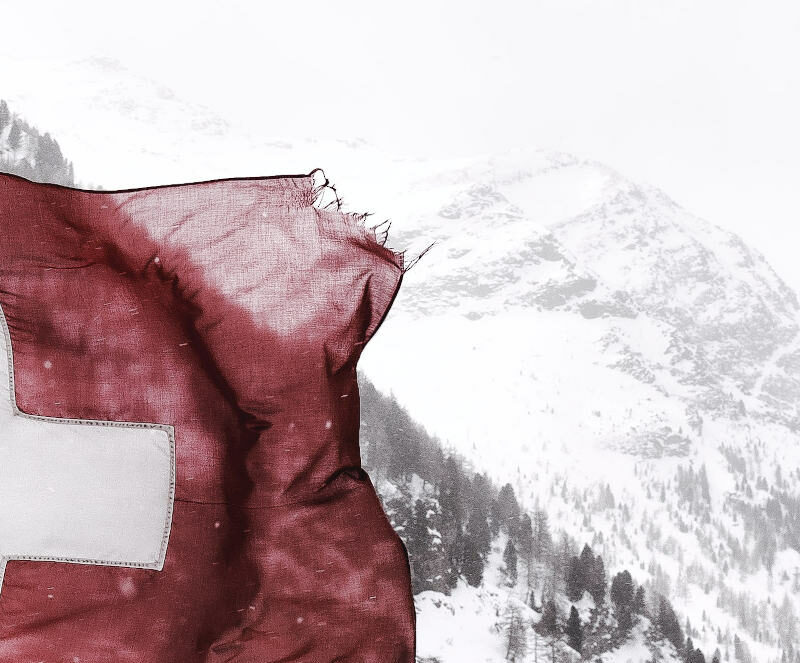 Weathered swiss flag infront of mountain