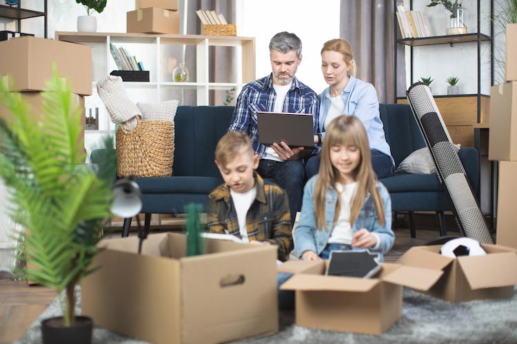 Couple with kids using laptop among boxes